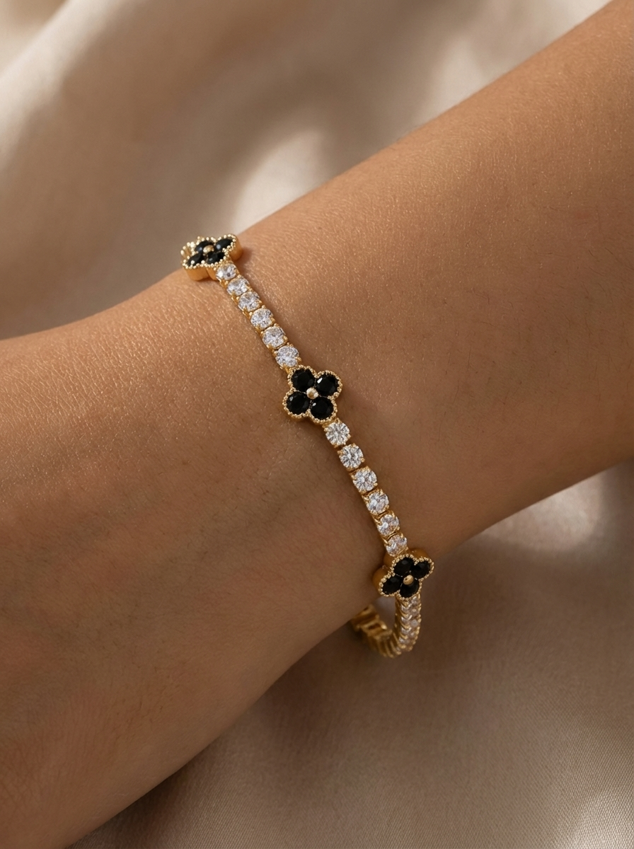Zarif Scarlett Bileklik, siyah zirkon taşları ve altın kaplama su yolu zinciri ile modern ve şık görünüm sunuyor. Atelier Duygu imzalı bu bileklik, üçlü yonca motifiyle sofistike bir lüks ifade ediyor.