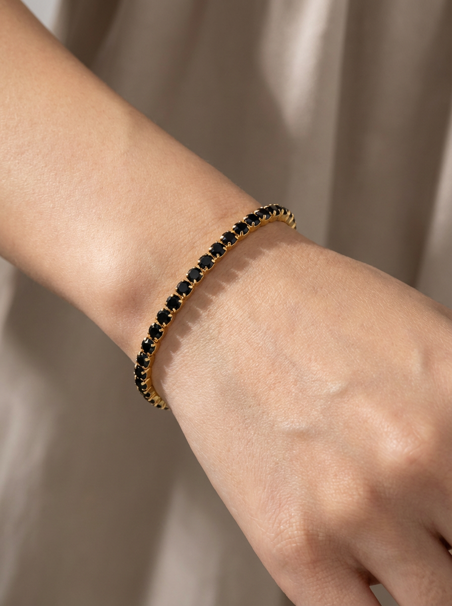 Atelier Duygu tarafından tasarlanan 2.5MM Black Gold Su Yolu Bileklik, zarif ve şık görünümüyle klasik su yolu bilekliklerin en sofistike hali. Siyah zirkon taşlarıyla bezeli ve altın kaplamasıyla lüks bir stil sunar.